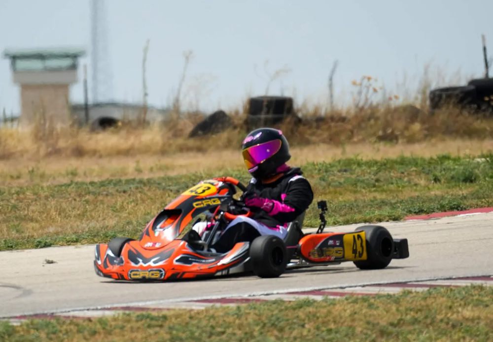 J.J.'s sister racing kart number 43 through a corner at a Texas kart track.